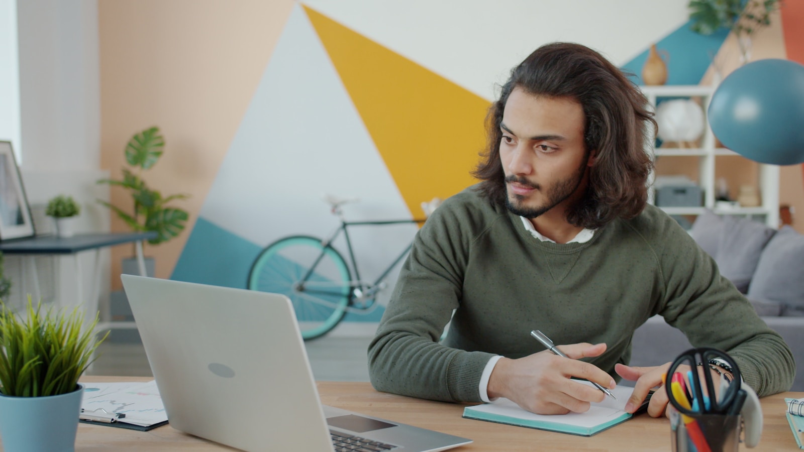 Person working at a desk with a laptop and notebook, planning a guest posting outreach strategy