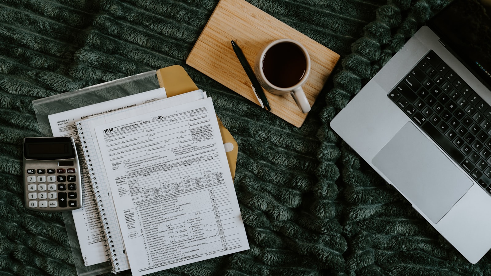 Laptop, papers, calculator and coffee during a link building budget planning session