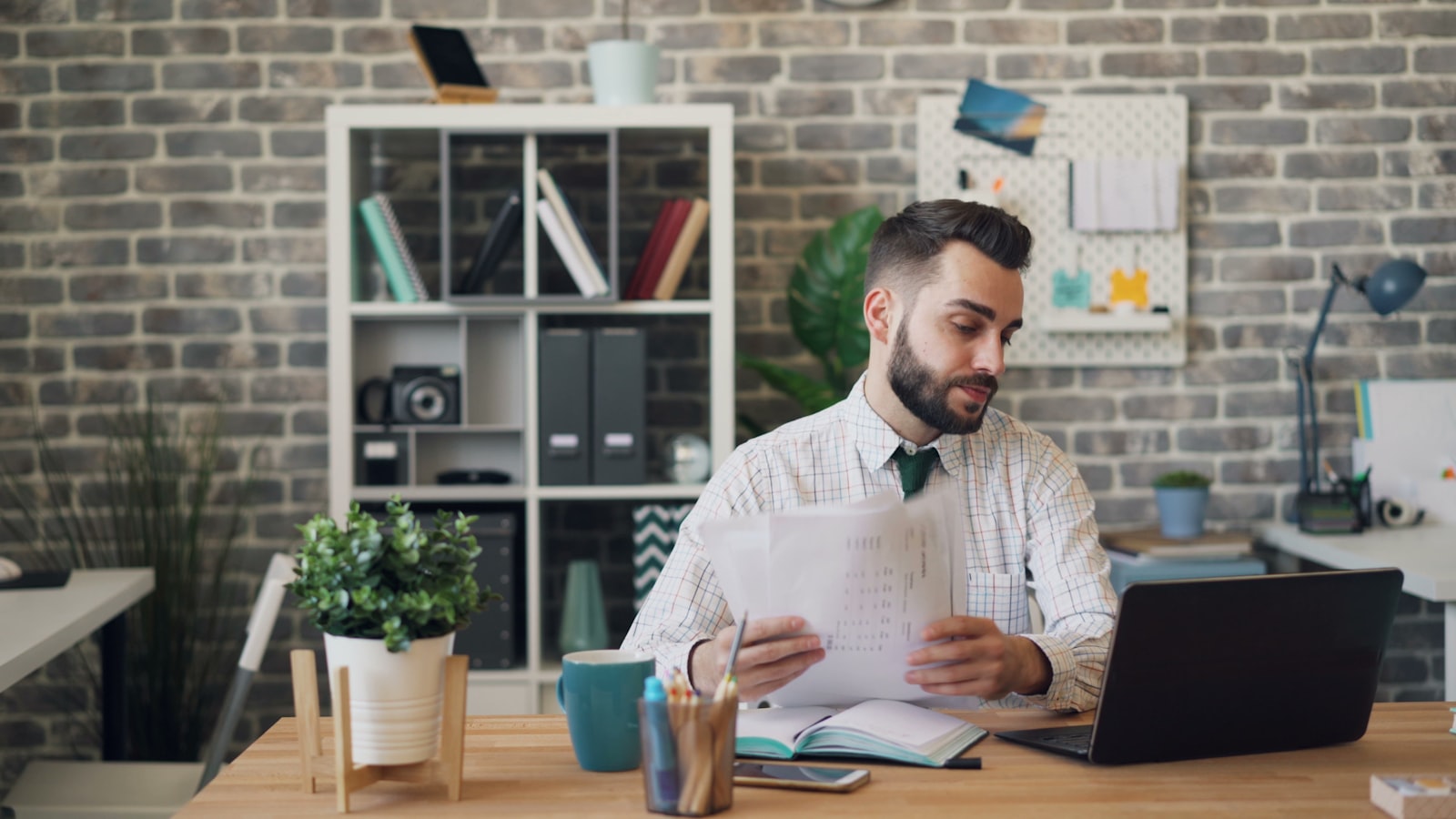 Person reviewing papers beside a laptop while comparing link building packages