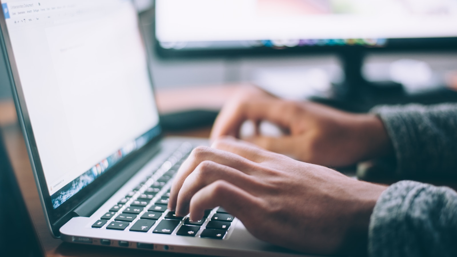 Person working at a desk with a laptop and notebook, researching resource pages for a link building campaign